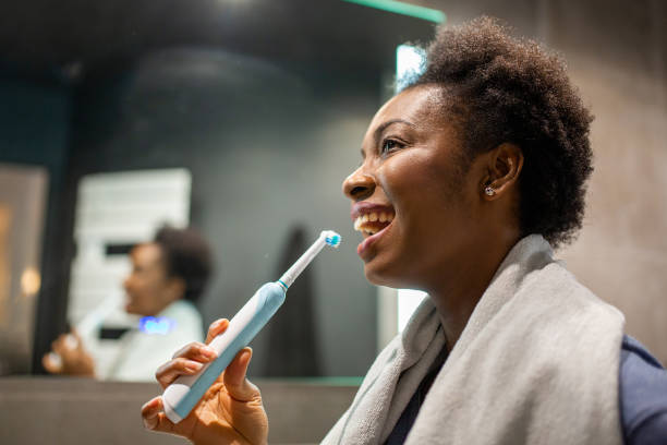 Side portrait smiling young black woman brushing teeth in bathroom